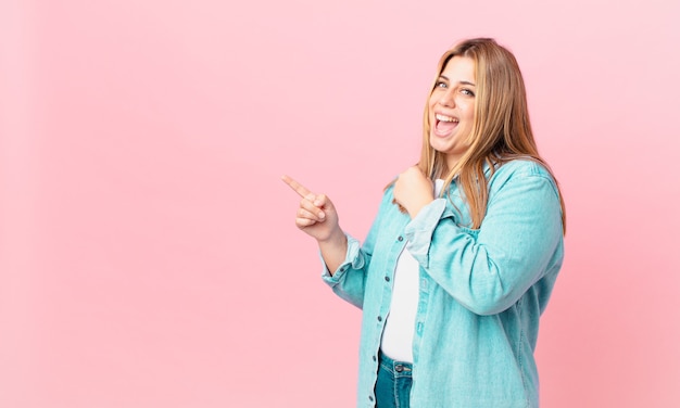 Bochtige mooie blonde vrouw die zich gelukkig voelt en een uitdaging aangaat of feest viert