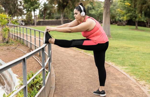 Bochtige vrouw doet sport workout routine buiten in stadspark