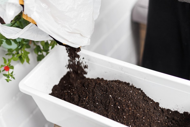 Bodem strooien in witte rechthoekige bloempot