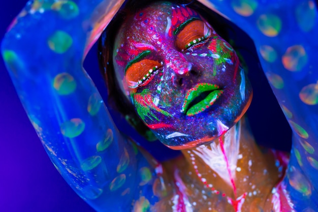 Body art glowing in ultraviolet light. body art on the body and hand of a girl glowing in the ultraviolet light