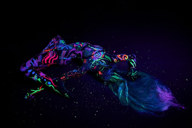 Foto body art op lichaam dansen in ultraviolet licht