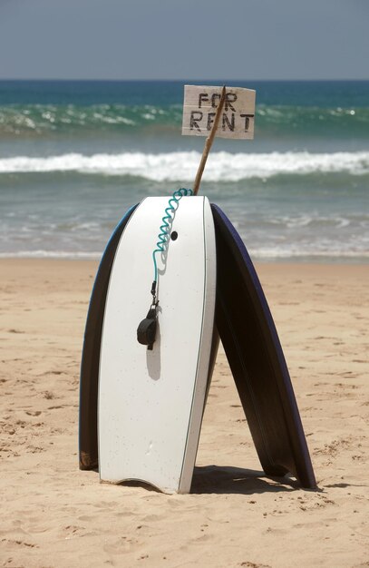 Photo body board on sand at beach against sea