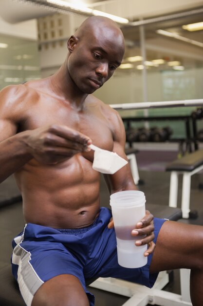 Body builder scooping up protein powder