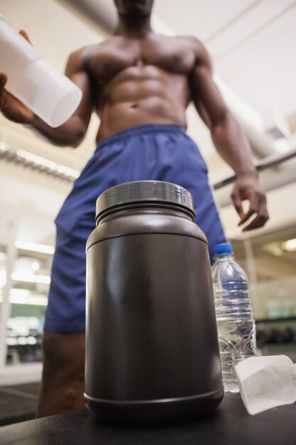 Photo body builder scooping up protein powder