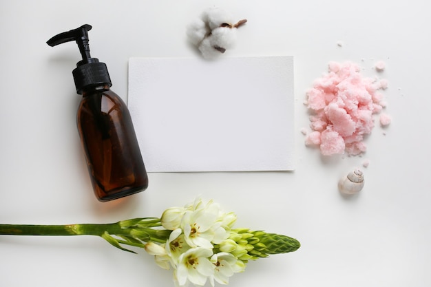 Body care cosmetics, flowers and white card