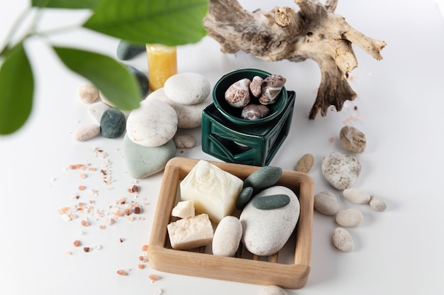 Body care items, a stack of round stones, sea salt, salt soap, on a white background