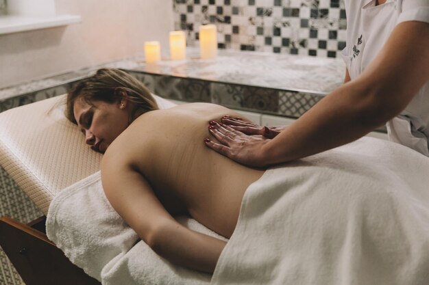 Body care A young girl makes a massage relaxes in a spa salon top view