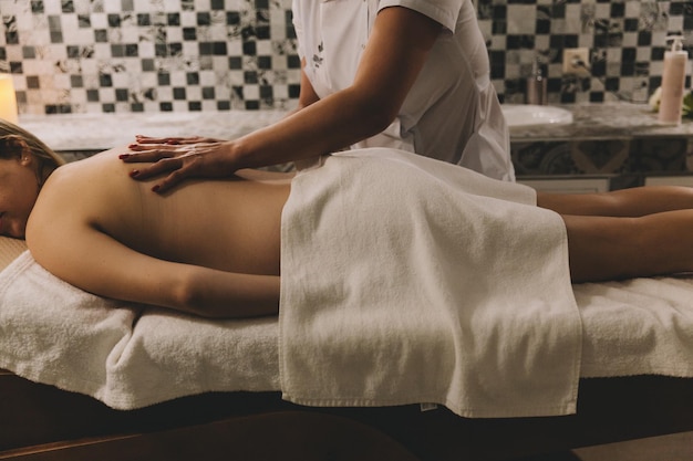 Body care A young girl makes a massage relaxes in a spa salon top view