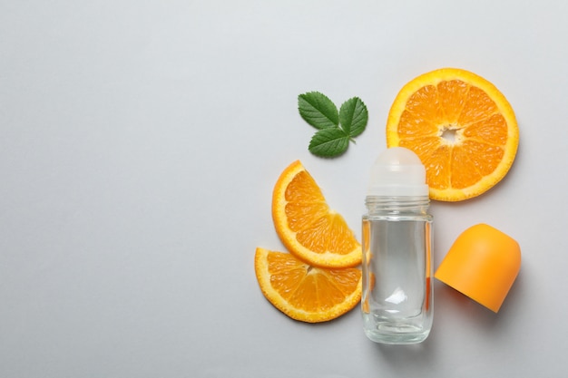 Body deodorant roll-on, bladeren en citrus op een grijze achtergrond