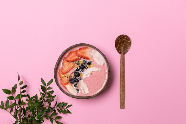 body detox - coconut bowl with fruit smoothie, fresh strawberries, blueberries, coconut chips