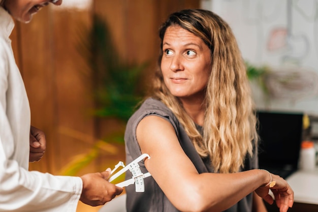 Photo body fat test using caliper on the female patient's arm