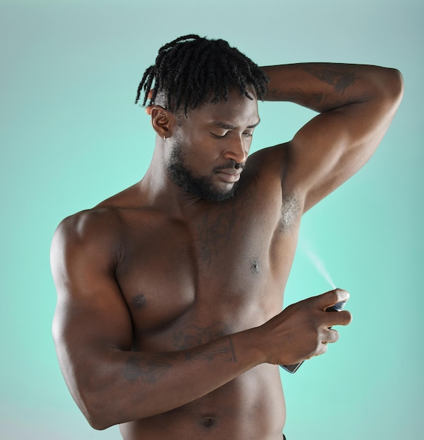 Body hygiene and black man with deodorant spray product for self care routine of people in studio Health wellness and cosmetic grooming of person with skincare at isolated green background