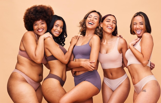 Photo body positive self love and portrait of women in studio in underwear for wellness beauty and diversity lingerie campaign natural and people on brown background for pride skincare and inclusion