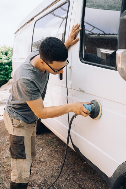 体を修理する道具を持った人が車を修理する