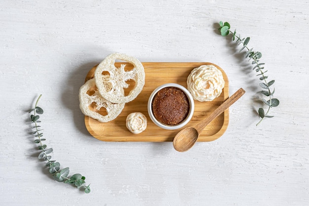 Body scrub and other care products on a wooden plate isolated