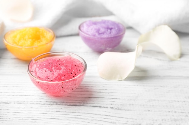 Body scrubs on wooden background