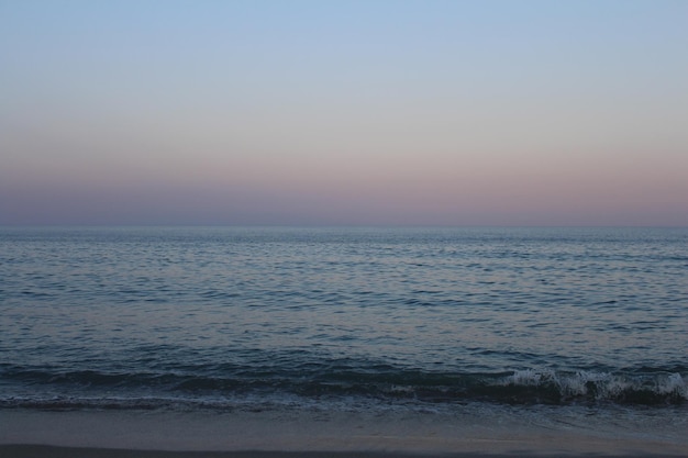 A body of water with a person on the beach