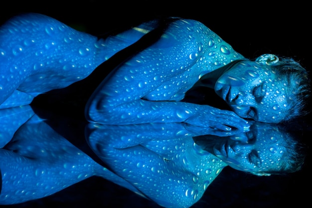 The body of woman with blue pattern and its reflection