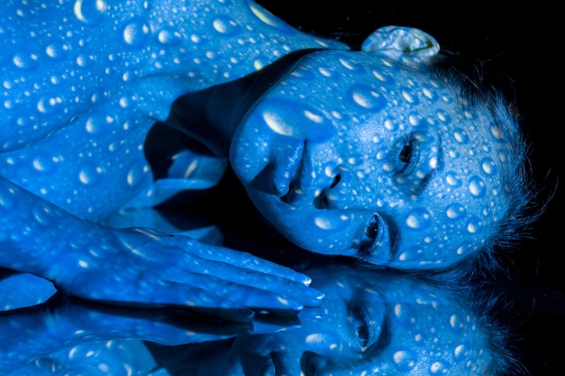 The body of woman with blue pattern and its reflection