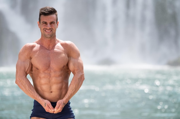 Bodybuilder buigt spieren voor waterval