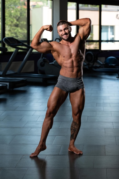 Bodybuilder die biceps pose uitvoert