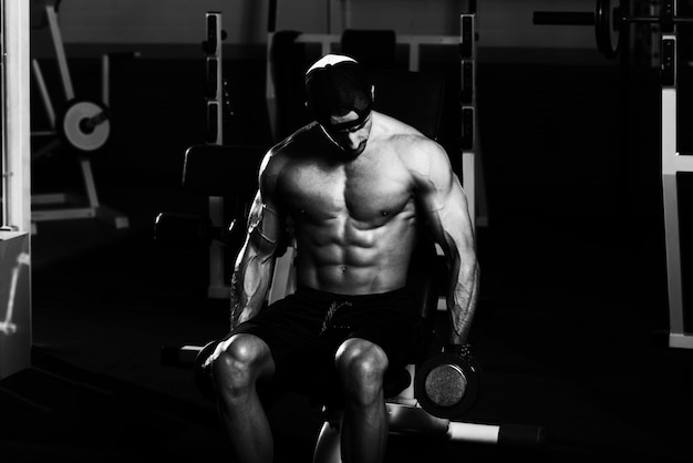 Bodybuilder die biceps traint met halters
