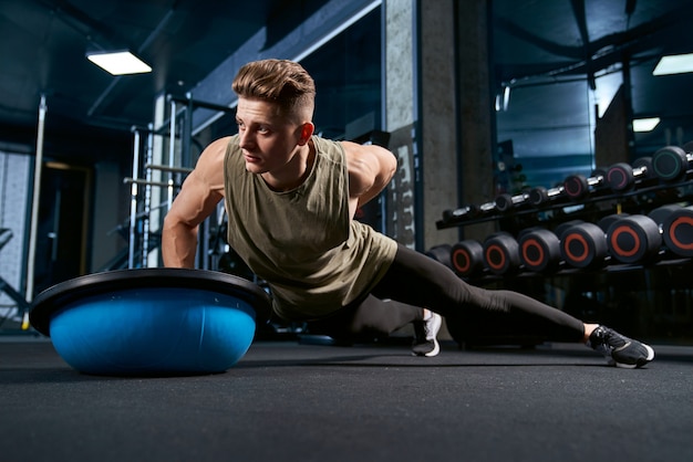 Bodybuilder doet push-ups aan de ene kant.