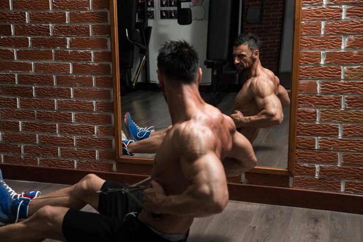 Photo bodybuilder doing heavy weight exercise for back on machine