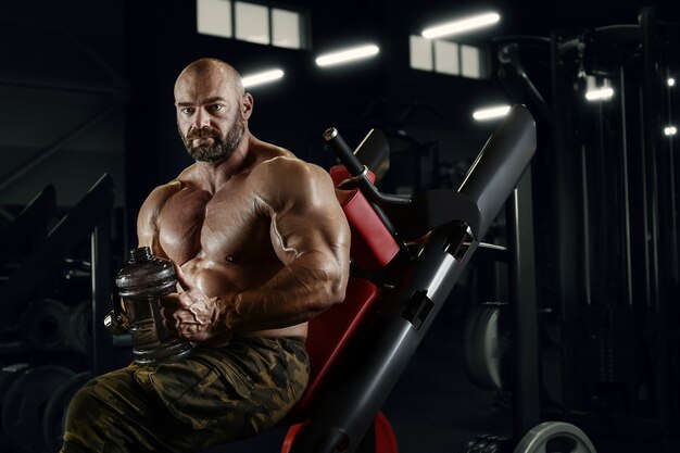 Bodybuilder drinking water after fitness workout