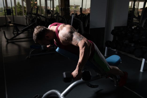 Bodybuilder Exercising Back With Dumbbells