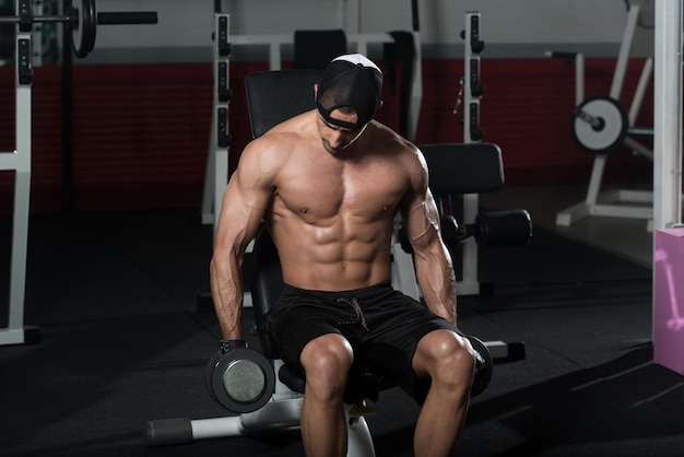 Bodybuilder Exercising Biceps With Dumbbells