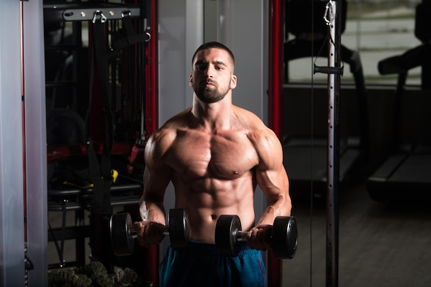 Bodybuilder Exercising Biceps With Dumbbells