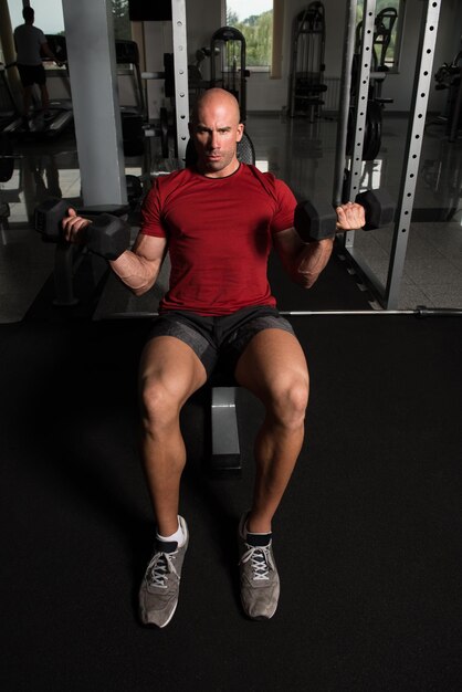 Bodybuilder Exercising Biceps With Dumbbells