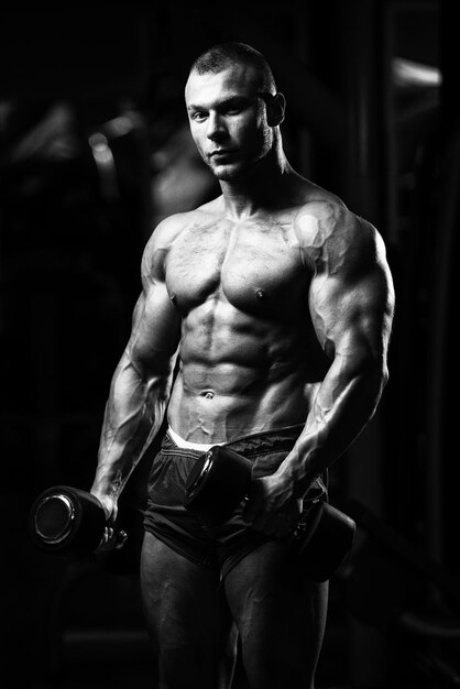 Bodybuilder Exercising Biceps With Dumbbells