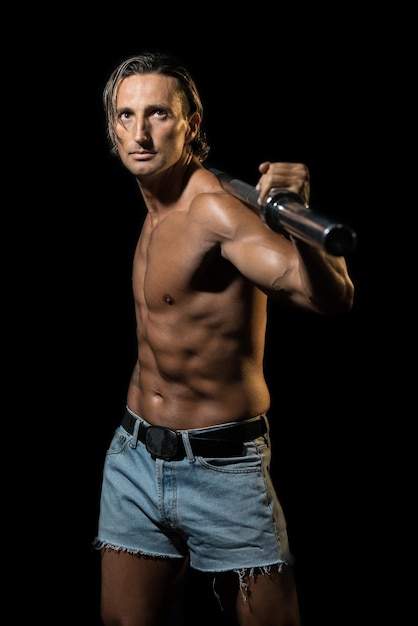 Photo bodybuilder exercising isolated on black background