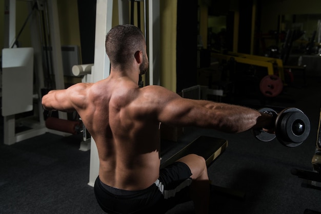 Bodybuilder Exercising Shoulders With Dumbbells