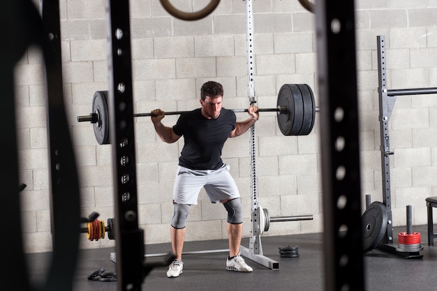 Bodybuilder exercising on squat rack