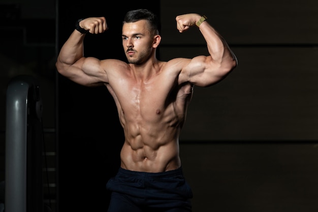 Bodybuilder Fitness Model Posing Double Biceps After Exercises