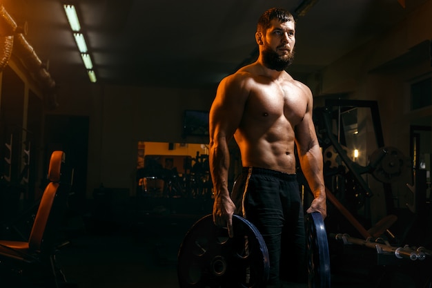 Culturista in palestra che esercita bilanciere