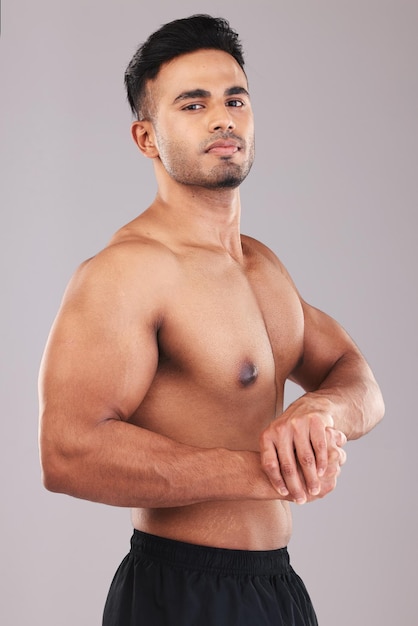 Bodybuilder health and fitness with a masculine man in studio on a gray background for exercise motivation Portrait gym and model with a male athlete posing to show his muscle bicep or body