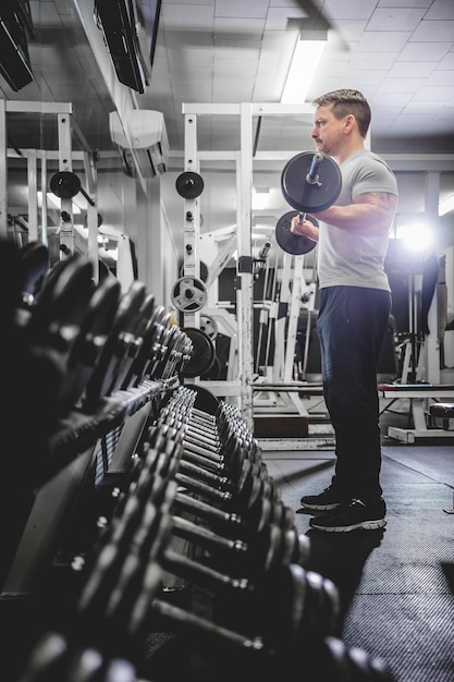 Photo bodybuilder lifting barbell in gym