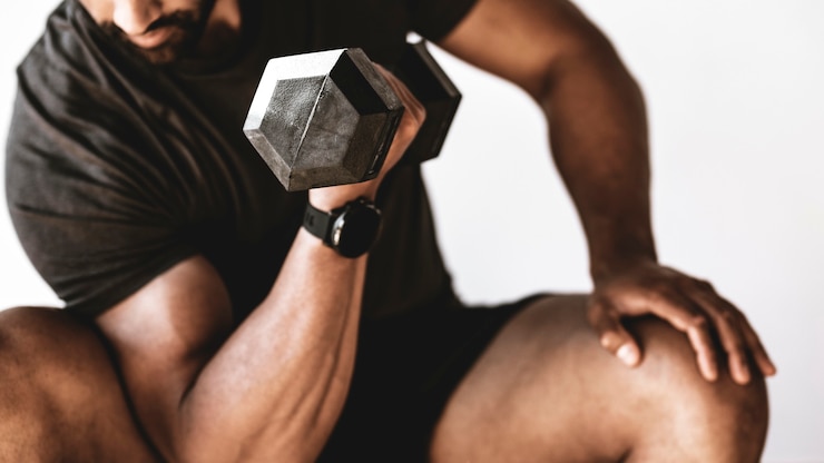 Photo bodybuilder lifting dumbbells in the gym