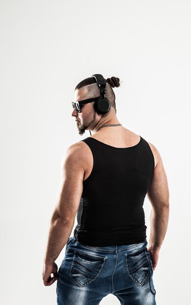 bodybuilder met koptelefoon en zonnebril op een witte achtergrond