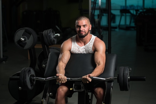 Bodybuilder performing biceps curls with a barbell