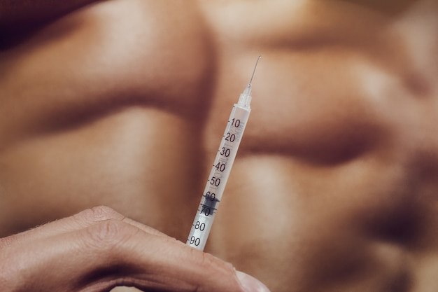Bodybuilder sterke man steroïde spuit injectie spieren