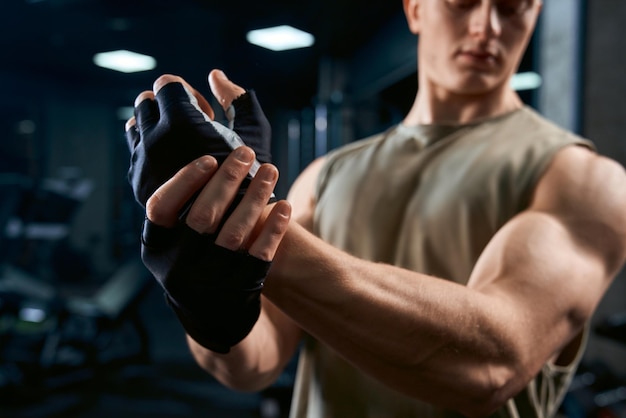 Bodybuilder stretching upper body in gym