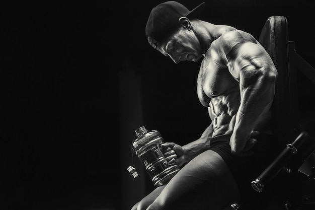 Photo bodybuilder strong athletic rough man drinking water after workout, fitness and bodybuilding concept