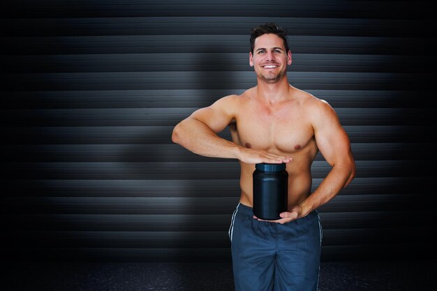 Photo bodybuilder with protein powder against black background