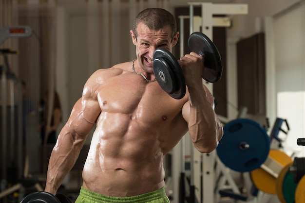 Bodybuilder Working Out Biceps In A Health Club