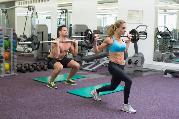 Bodybuilders lifting barbells together at crossfit